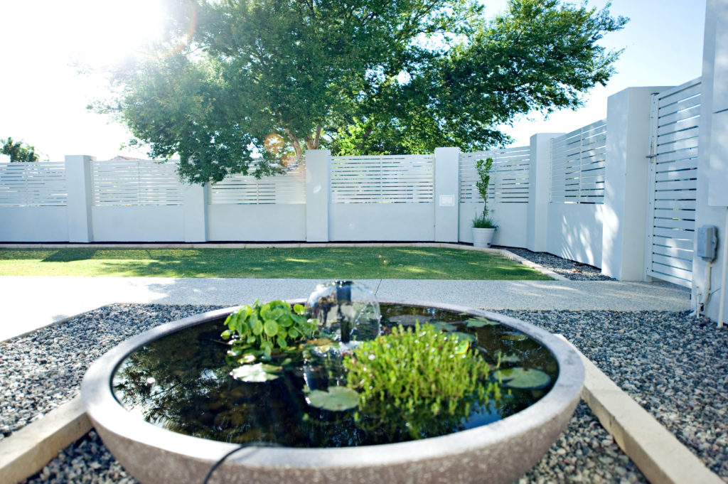 White slat Hamptons Style louvre fencing in courtyard