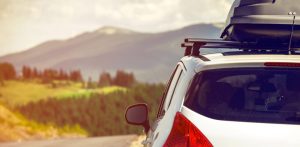 car with a roof rack driving to a holiday in the hills